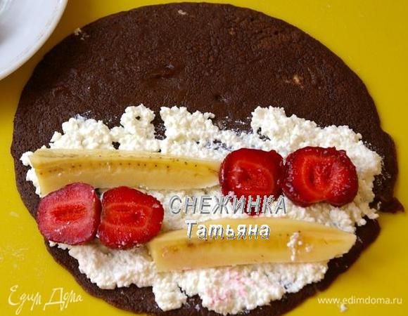 На 2/3 блинчика кладем начинку. Банан разрезаем пополам сначала поперек, затем вдоль, то есть на 8 частей. Клубнику разрезаем на половинки. Кладем кусочки банана и клубники на начинку в шахматном порядке.