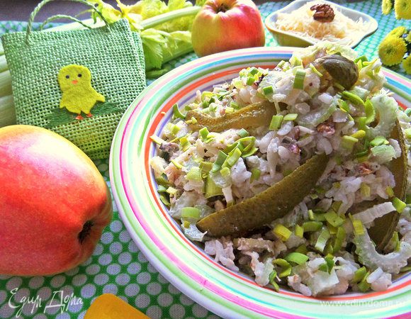 Салат выкладываем горкой, украшаем маринованным огурчиком. Посыпаем остатками лука или другой зелени.