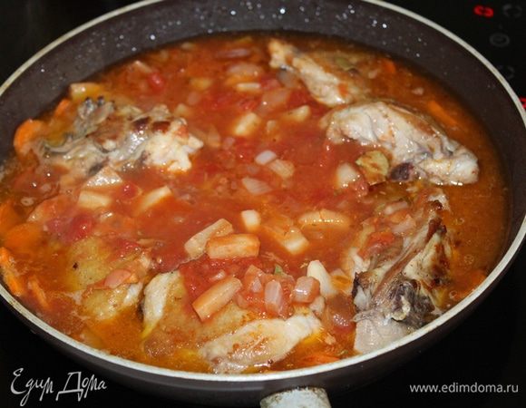 Добавляем томатно-овощную смесь к курице. Доливаем воды так, чтобы она слегка покрывала содержимое сковороды. Доводим до кипения и тушим на небольшом огне под закрытой крышкой около 15 минут. Затем снимаем крышку и тушим еще 15 минут, до полной готовности курицы и моркови.