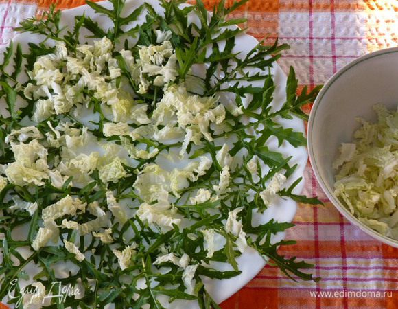 Пекинскую капусту измельчить полосками. Часть выложить на блюдо.