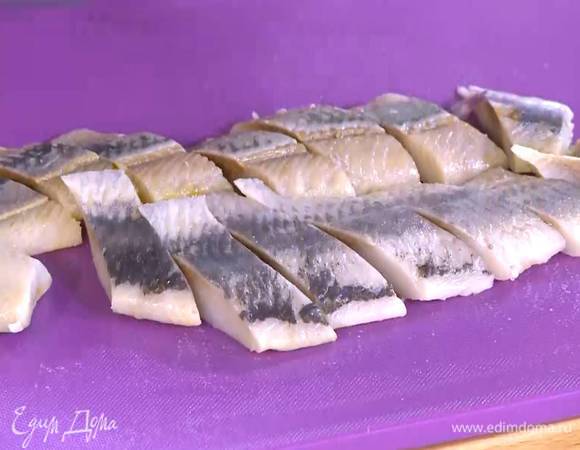 Сельдь замочить в молоке на 10‒15 минут, затем молоко слить, промокнуть сельдь бумажным полотенцем и нарезать тонкими кусочками наискосок.