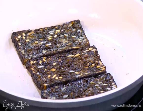 Разогреть в сковороде 1 ст. ложку оливкового масла и обжарить черный хлеб с двух сторон, затем выложить его на бумажное полотенце.