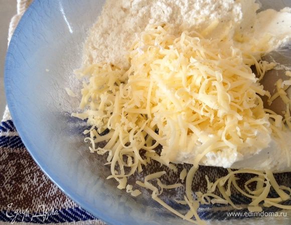 Сыр натереть на мелкой терке и добавить к творогу. Туда же добавить муку (1,5 — 2 ст.л.) и щепотку соли. Хорошо все перемешать!