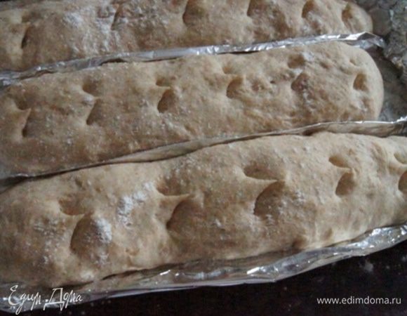 Сделать из фольги такую форму для батонов, присыпать ее мукой. Разделить тесто на 3 части, сформировать батончики, слегка растянуть их. Оставить в теплом месте на 30-40 минут. Сделать надрезы.
На фото уже расстоявшиеся батоны.