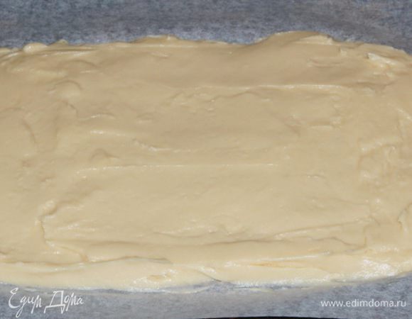 Противень выстилаем пекарской бумагой и равномерно распределяем тесто.