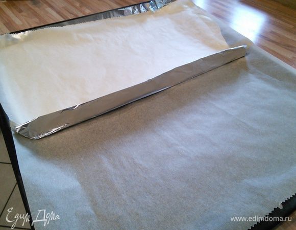 Начнем с бисквита. Подготовим противень. Разрежем лист пергаментной бумаги на половину. Одну половину выкладываем на противень, другую фольгой, образуя небольшой бортик. Фольгу накрываем второй половиной бумаги. Эти приготовления необходимы для того, чтобы выпечь бисквит с фисташками и без. 