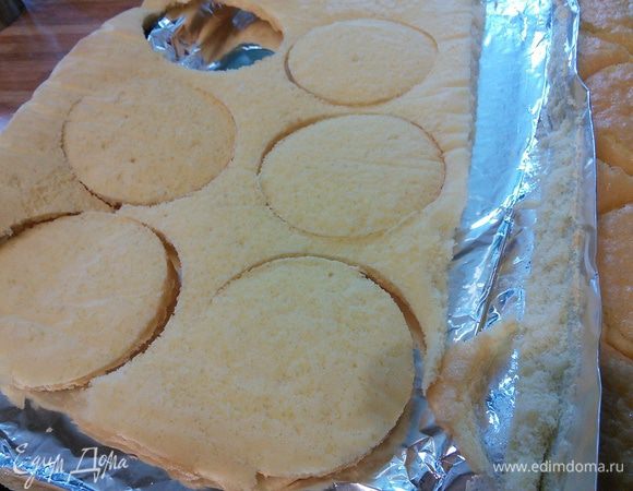 Легче будет, если перевернуть бисквиты вверх бумагой и снять ее. 