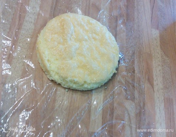 Теперь берем кусочек пленки выкладываем на него бисквит без фисташек и опускаем в кольцо. Разравниваем пленку. 