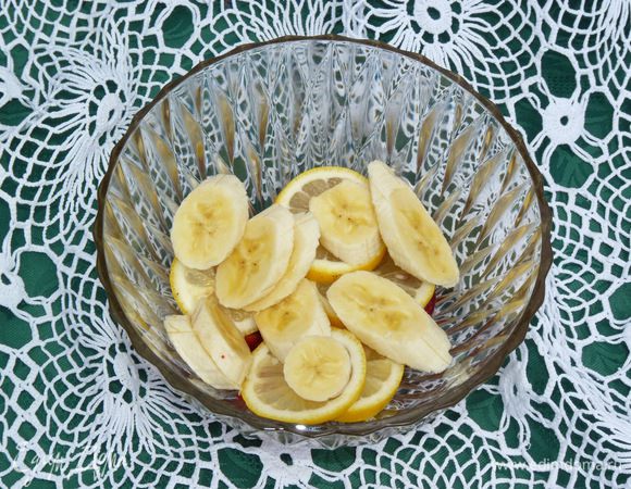 Нарезать бананы и сложить к фруктам.