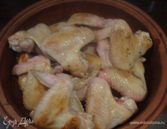 Крылышки натереть солью, обжарить до золотистой корочки и сложить в сотейник.