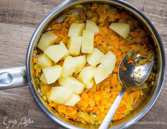 Чеснок порубить и добавить в сотейник, обжаривать все вместе пару минут. Картофель нарезать кубиком и добавить к обжаренным овощам.