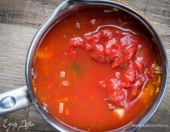 Влить томаты в собственном соку и воду. Довести до кипения, посолить, поперчить, добавить сахар (немного, так, чтобы сбалансировать кислоту томатов). Уменьшить огонь и варить 30-40 минут.