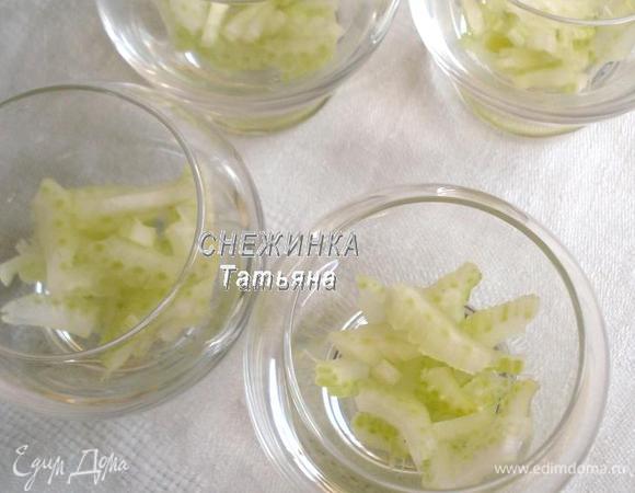 Сельдерей очищаем от жестких волокон. Нарезаем тонкими пластиночками. Раскладываем первым слоем в бокалы, стаканы, пиалы…