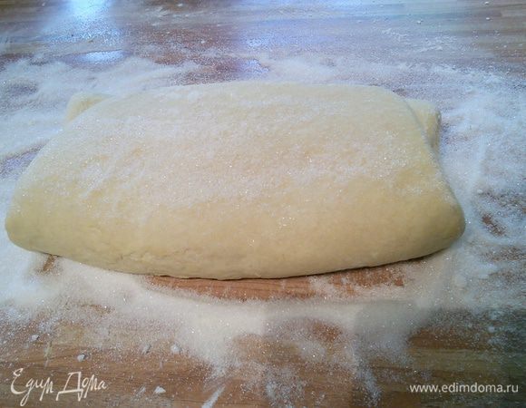 Рабочую поверхность щедро присыпать кристаллическим сахаром и раскатать тесто в прямоугольник размером ~ 60 x 40 см. Тесто при раскатке часто переворачиваем, чтобы сахаром покрылись обе поверхности. 