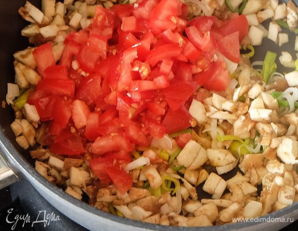 В сковороду наливаем немного растительного масла. Лук-порей нарезаем полукольцами, мякоть баклажана — мелкими кусочками, помидоры — мелкими кубиками. Чеснок мелко рубим. Жарим лук на среднем огне минуты 3 до мягкости, добавляем баклажаны, чеснок, помидоры и готовим 5–7 минут, периодически помешивая.