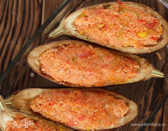 Достаем из духовки баклажановые лодочки. Выкладываем в них готовую начинку. Снова укладываем уже фаршированные лодочки в форму, на дно формы наливаем немного кипятка (буквально пару столовых ложек).