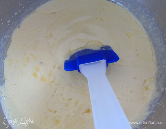 Во взбитые яйца с сахаром влейте растопленное масло и перемешайте лопаткой.