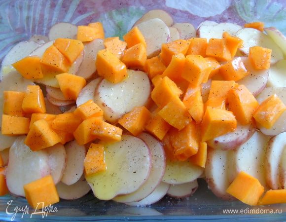 Картофель помойте, не очищайте, нарежьте кружочками и выложите в форму для запекания. Тыкву нарежьте кубиками и отправьте к картофелю. Посолите, поперчите и сбрызните оливковым маслом.  