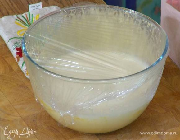 В яичную массу, постоянно перемешивая венчиком, влить горячие сливки с молоком, затем затянуть посуду пищевой пленкой.