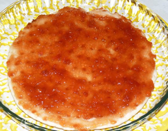 Намазать джемом основу для пиццы.