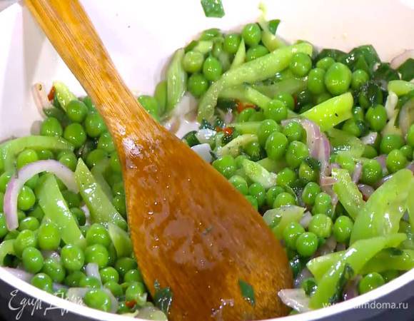 Зеленый горошек всыпать к овощам, перемешать и еще немного все обжарить.