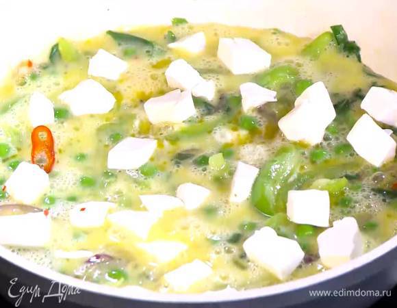 Фету нарезать маленькими кубиками и выложить на яйца с овощами.