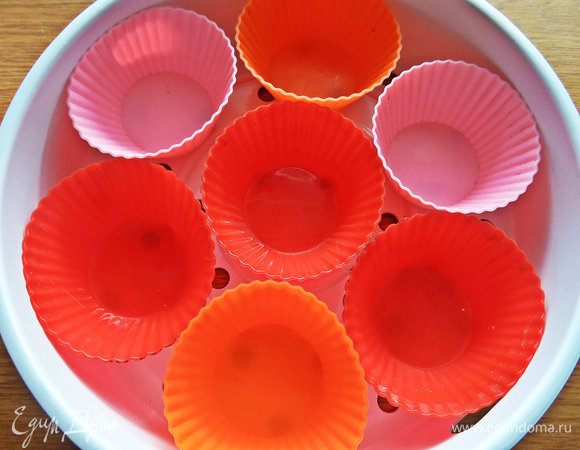 Смазываем формочки для кексов маслом и ставим в поднос.