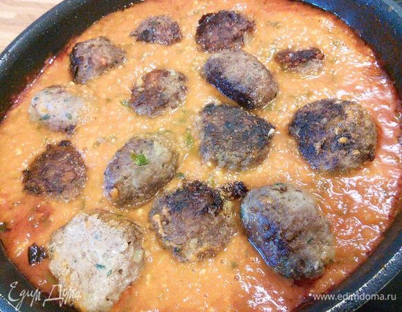 Разогрейте духовку до 200°С. Соус необходимо посолить, поперчить, добавить сахар и по желанию острый соус чили. Выложить тефтели в соус. 