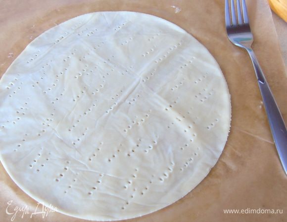 Снимаем верхний лист пергамента и вырезаем круг, накалываем вилкой и выпекаем в разогретой до 220°С духовке 5 минут до золотистого цвета. Так поступаем со всеми коржами. Обрезки тоже выкладываем на противень и выпекаем.