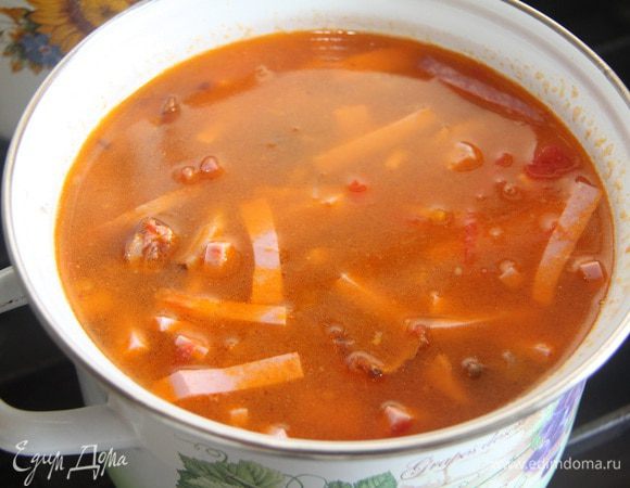 В бульон положить мясную нарезку и овощную заправку. Довести до кипения.