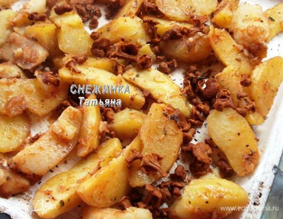 Вынимаем из горячей духовки противень, выкладываем картофельные дольки на противень. Сверху распределяем лисички. Ставим запекаться при 220-230°C на 20 минут.