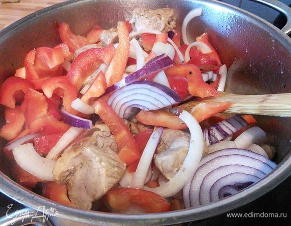 В глубокой сковороде или кастрюле  разогреть масло и обжарить мясо в течении 3 минут. Добавить нарезанный полукольцами лук и перец, обжарить вместе с мясом. 