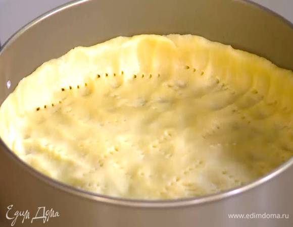 Тесто равномерно выложить в разъемную форму, сформировав небольшие бортики, и часто наколоть вилкой, сверху поместить бумагу для выпечки и насыпать горох или фасоль.