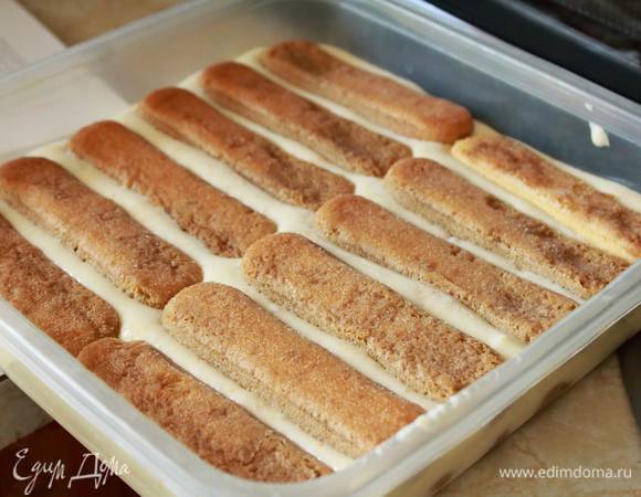 Печеньку смочить в кофе и уложить в емкость, где будет собираться тирамису. Удобнее на каждую отдельную порцию брать отдельный бокал/пиалку, но можно и все в одной делать — просто при подаче это будет иметь менее эстетический вид :)
Один слой печенек накрываем кремом, затем еще один слой печенек и снова крем.