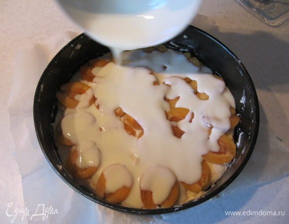 Приготовить заливку. Для этого взбить вилкой сметану, сахар и яйцо.
Покрыть заливкой абрикосы. Отправить пирог в предварительно разогретую до 180°C духовку на 40-50 минут (следите за духовкой!).