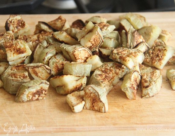 Нарезать запеченные кружки баклажанов на четвертинки.