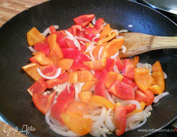 Из вока удалить почти все масло (оставить приблизительно 2 ст л) и обжарить лук с чесноком буквально 2 мин. Добавить перец и обжарить ровно до тех пор, как перец начнет отдавать свой аромат. 