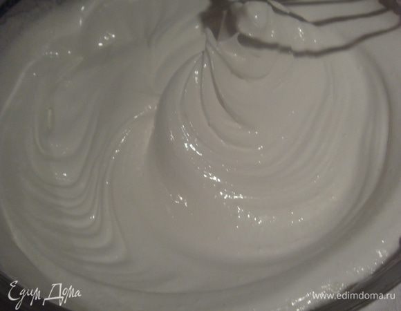 Белки взбиваем в крепкую пену (хорошо когда белки комнатной температуры),  сахар перемешиваем с крахмалом, по чуть-чуть добавляем в белки и взбиваем белки до устойчивых пиков, пока смесь не станет густой и блестящей.