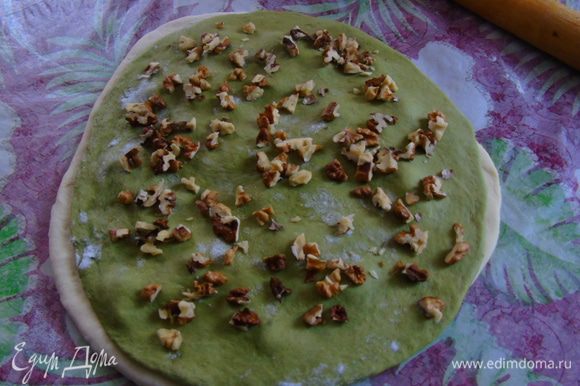 Раскатываем зеленое тесто и присыпаем оставшимися орехами.