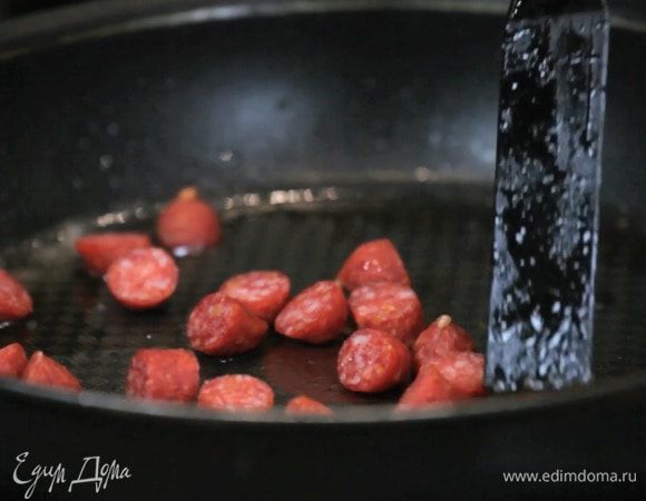 Отдельно обжарить нарезанную колбасу чоризо.