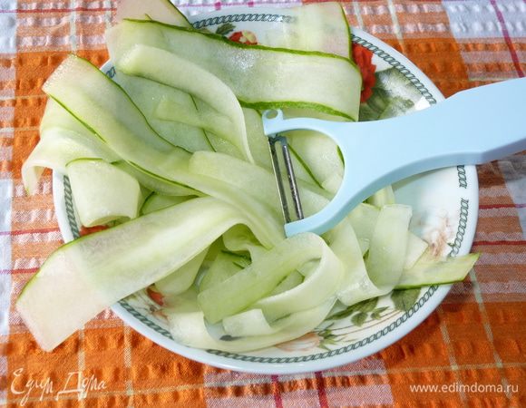 Огурцы нарезать тонкими продольными пластинами, не захватывая серединки с семенами.