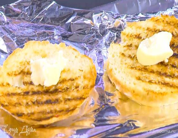 Противень выстелить фольгой, выложить обжаренные ломтики бриоши и смазать их сливочным маслом.