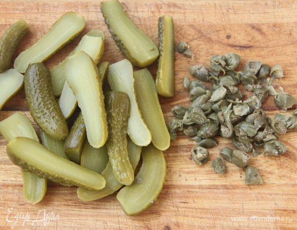 Порубить каперсы и маринованные огурчики.