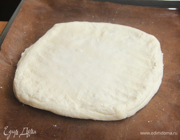 Слоеное тесто автор делает сама, но я в целях экономии времени использовала готовое тесто. Можно приготовить тесто самим по рецептам с нашего сайта. Слоеное тесто вырезать в виде круга диаметром 24 см.
Я не стала вырезать, просто руками постаралась придать квадратному пласту форму круга. Но лучше вырезать.
