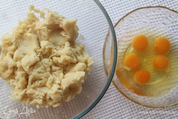 Дать тесту немного остыть (пару минут), продолжая его мешать. Ввести по одному яйца, взбивая тесто с помощью миксера.