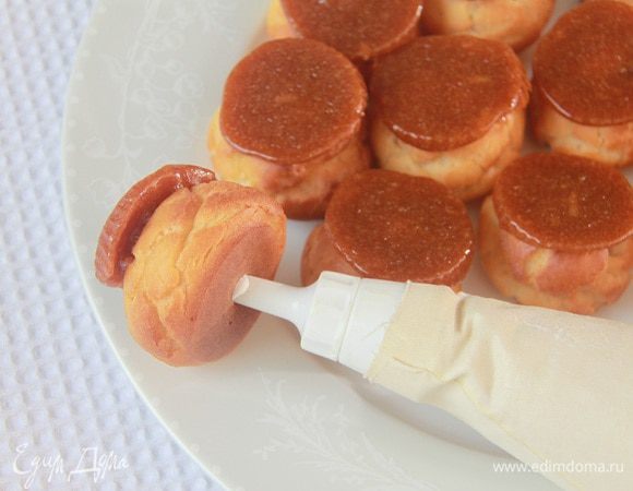 Оставшимся сливочным кремом наполнить профитроли.