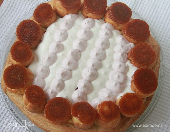 Выложить профитроли по окружности торта карамельной крышечкой вверх. Торт охладить.