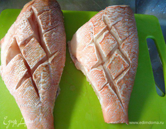 Сделать на кожице надрезы с обеих сторон. Натереть рыбку с обеих сторон солью и белым молотым перцем.