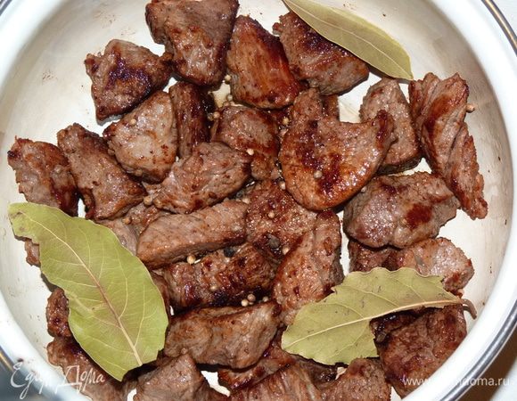 Поджаренное мясо сложить в кастрюльку, добавить лавровый лист и кориандр, пару горошин черного перца. Залить кипятком, чтобы вода была на 1 см выше мяса и варить 35 минут. Затем извлечь лавровый лист.