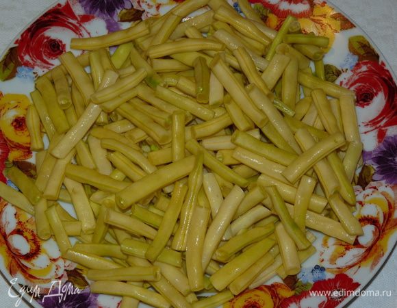 Обрезать носики и хвостики, перерезать напополам. Добавить к мясу и тушить 15 мин на медленном огне. При необходимости добавить воду.